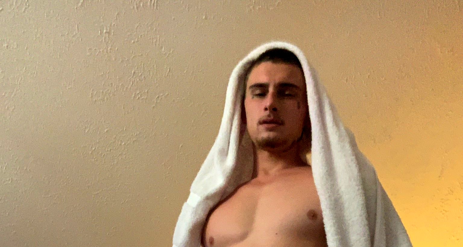Trik under a towel in warm lamplight, eyes down